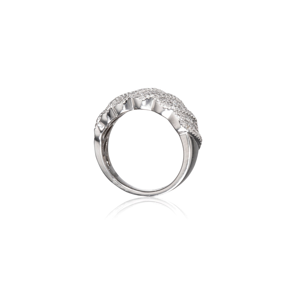 A white gold ring with a textured, scalloped top set with small clear stones, shown on a plain white background with a soft reflection below.