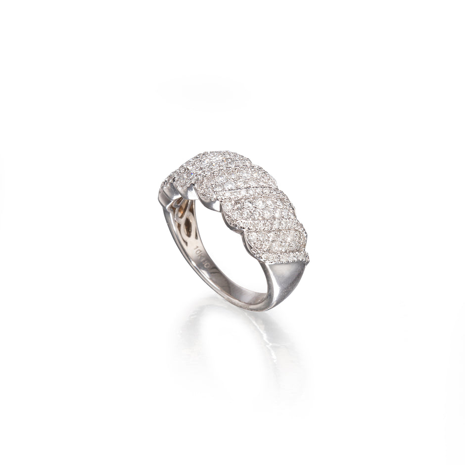 A silver pavé ring with a wavy, layered design, photographed on a clean white background with a soft reflection.