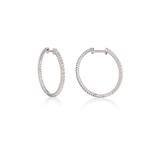 A pair of white gold hoop earrings with a textured, rope-like outer surface paved with small clear stones, shown on a white background with a soft reflection.