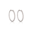 A pair of white gold hoop earrings adorned with small clear stones set in a textured, rope-like border, displayed on a clean white background with a soft reflection below.