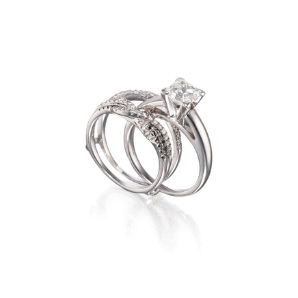 A white gold wedding ring set featuring a solitaire engagement ring with a rectangular clear gemstone and a matching band with pavé-set clear stones, displayed on a clean white background with a soft reflection.