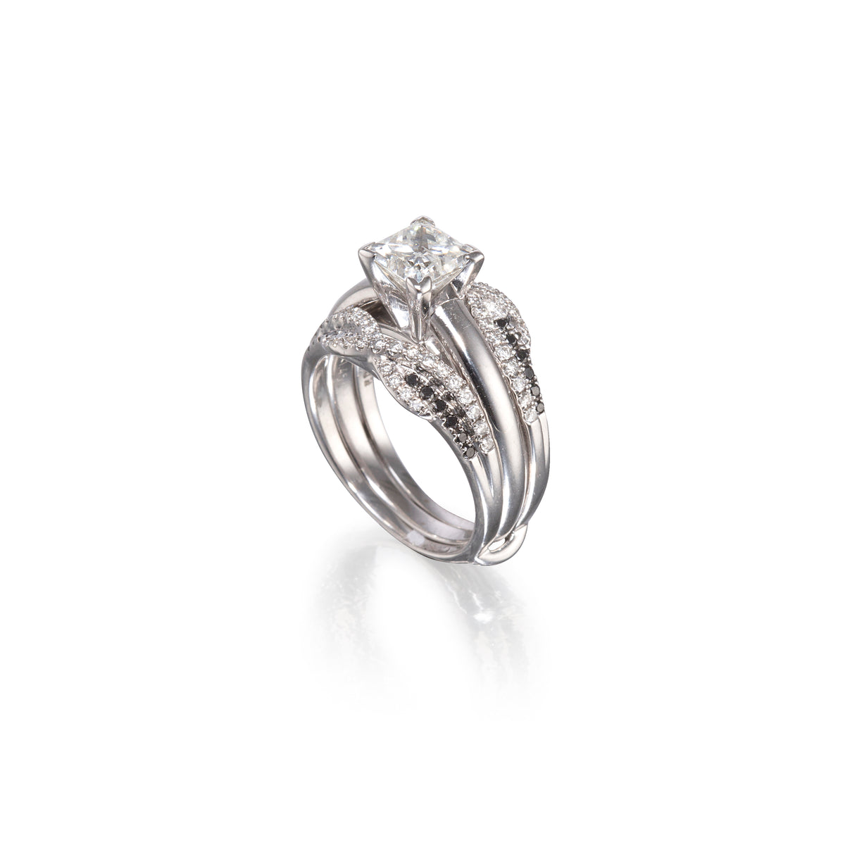 A white gold wedding ring set featuring a princess-cut diamond center stone and pavé-set diamonds along the wrap-around bands, shown on a clean white background with a soft reflection.
