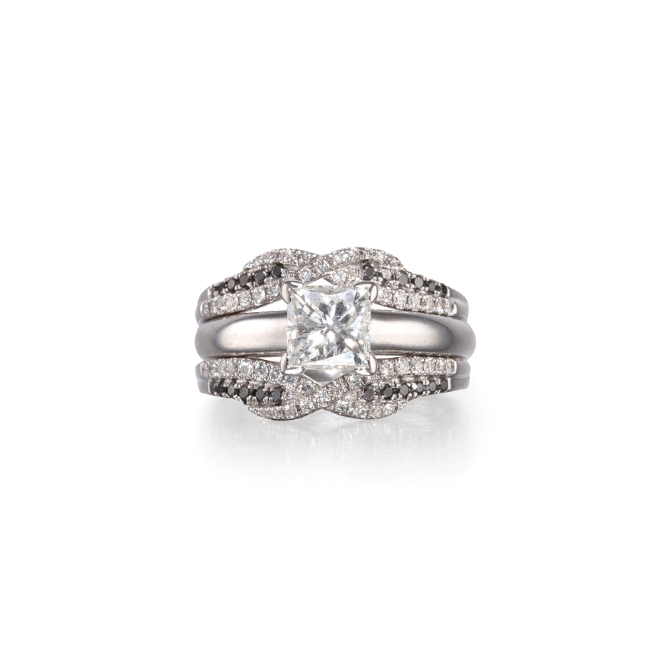 A white gold double ring set featuring a central princess-cut clear gemstone surrounded by pavé accents, with a smaller matching ring nested behind it, shown on a white background.