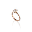 A rose gold engagement ring featuring a clear gemstone in a four-prong setting, shown on a clean white background with a soft reflection below.