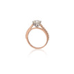 A rose gold engagement ring featuring a round-cut diamond center stone in a four-prong setting, with small pavé diamonds, shown on a clean white background with a soft reflection.
