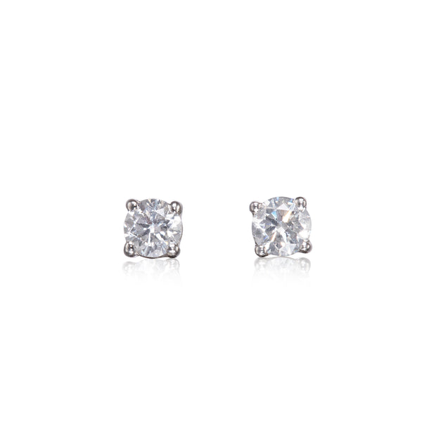 A pair of white gold stud earrings with round brilliant-cut clear gemstones in a four-prong setting, shown on a plain white background with soft reflections below.