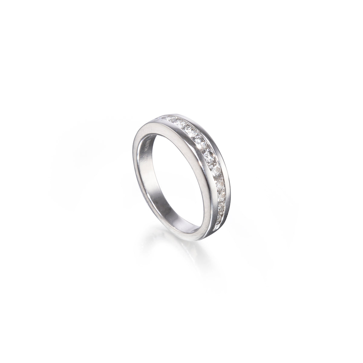 A white gold band ring featuring a channel-set row of clear round gemstones along the upper half, shown on a clean white background with a soft reflection.
