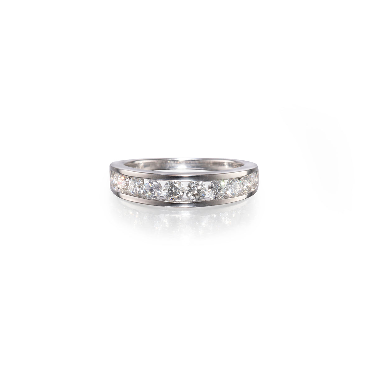 A white gold band ring paved with round clear gemstones, shown on a clean white background with a soft reflection below.
