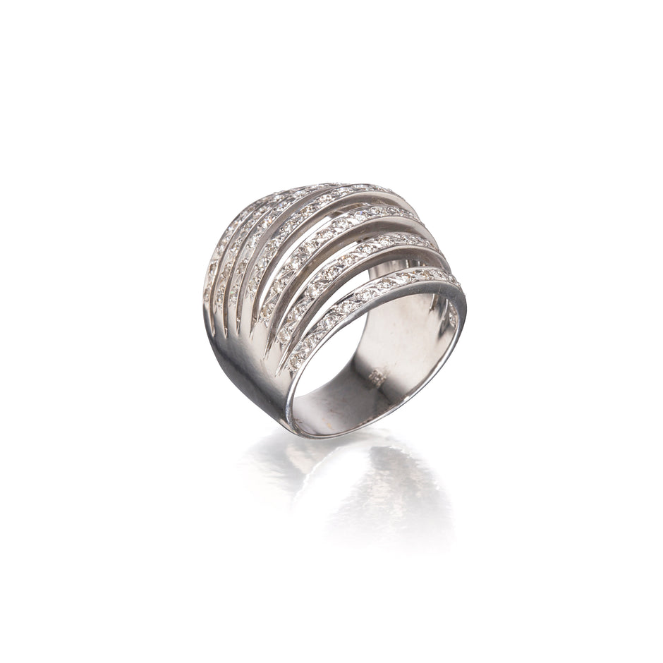 A white gold wrap-around ring with multiple horizontal bands of small clear stones, photographed on a clean white background with a soft reflection below.