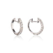 A pair of white gold hoop earrings with clear pavé-set stones, shown from the side on a white background with a soft reflection below.