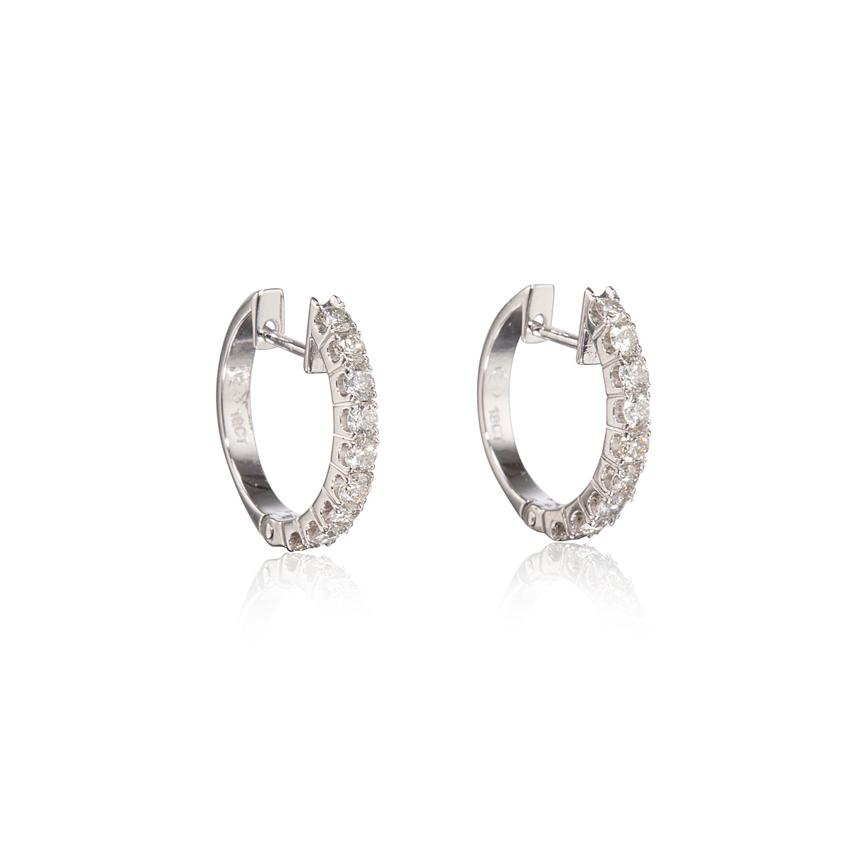 A pair of white gold huggie hoop earrings adorned with clear pavé-set round stones, shown on a clean white background with a soft reflection below.