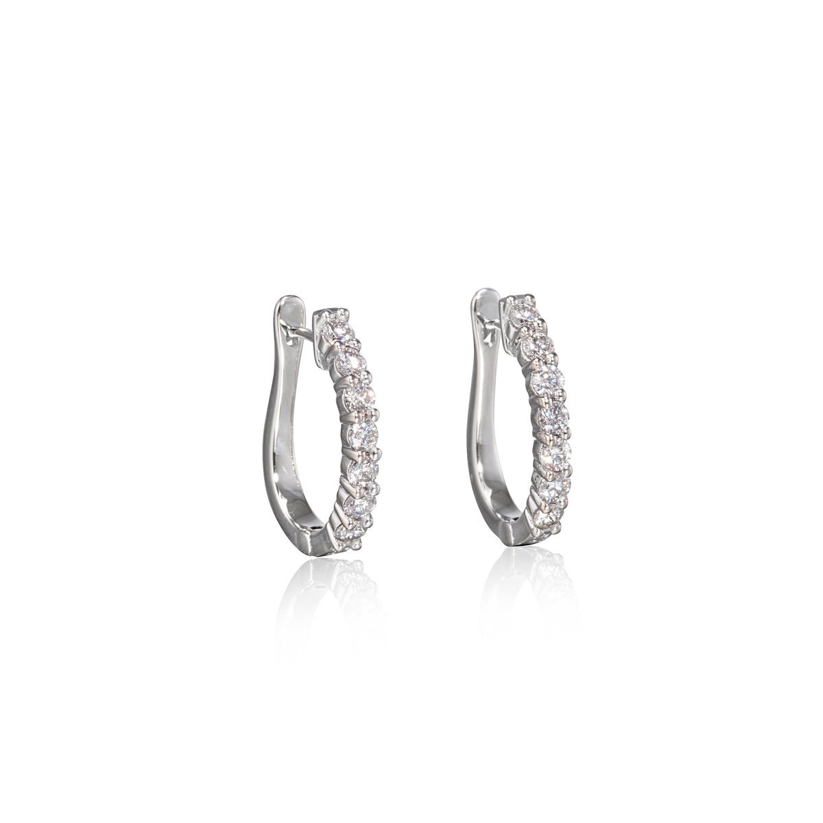 Pair of white gold hoop earrings with clear stones on a white background
