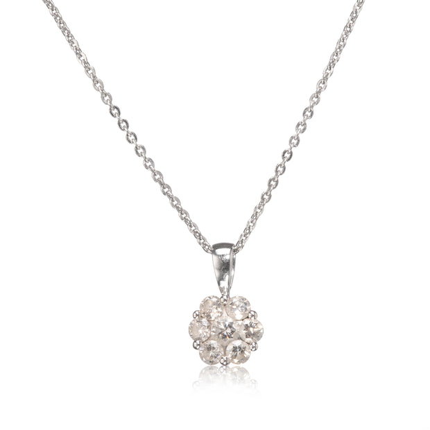 A white gold chain necklace with a round cluster pendant made of clear gemstones in a white gold setting, shown on a white background with a soft reflection below