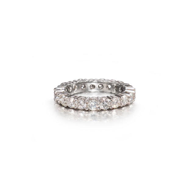 A White gold eternity ring paved with round brilliant-cut diamonds, shown on a clean white background with a soft reflection.