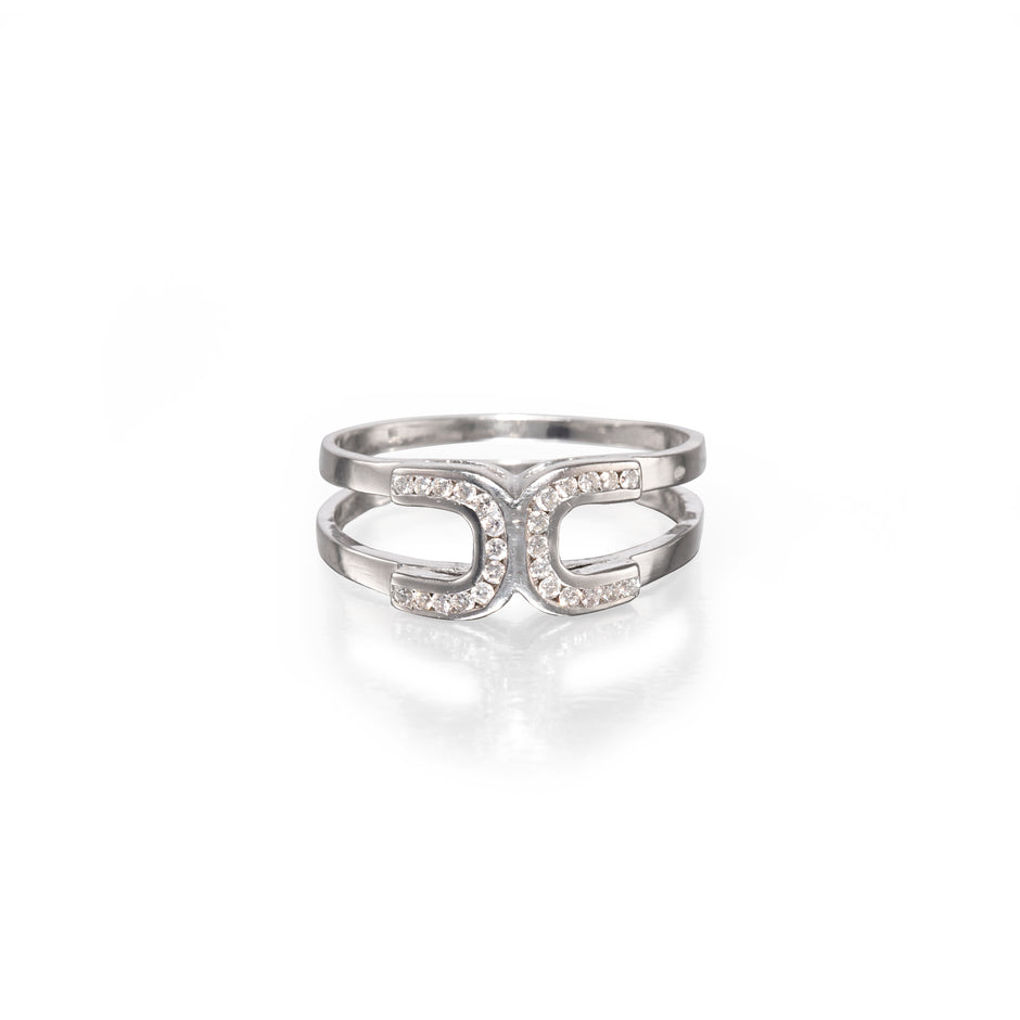 A white gold double horseshoe ring set with small clear stones, shown on a clean white background with a soft reflection below.