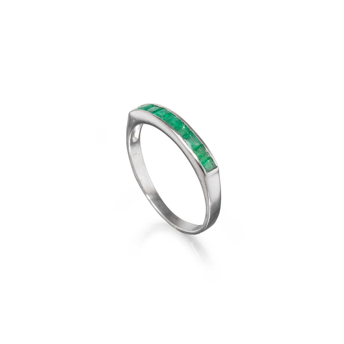 A white gold ring featuring a channel-set row of vibrant green emerald-cut gemstones, shown on a clean white background with a soft reflection.
