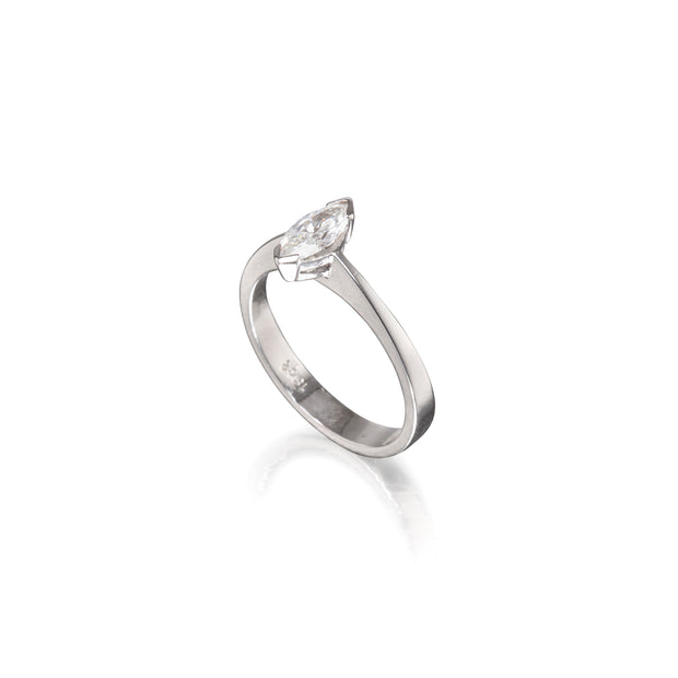 A white gold solitaire ring featuring a marquise-cut clear gemstone in a prong setting, shown on a clean white background with a soft reflection below.