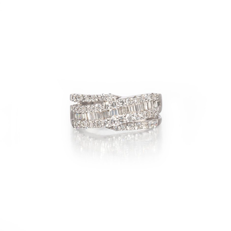 A white gold wrap-around ring with multiple rows of baguette and round-cut clear stones, shown on a clean white background with a soft reflection below.