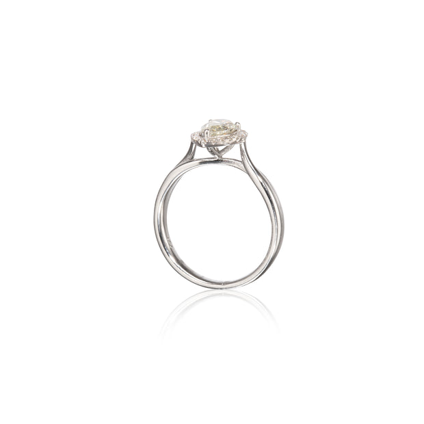 A white gold solitaire ring with a round-cut clear gemstone in a prong setting, shown on a clean white background with a soft reflection below.