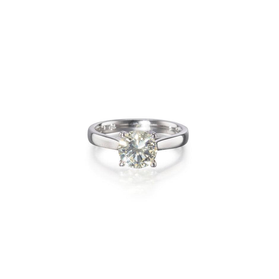 An 18ct white gold solitaire diamond ring with a round brilliant cut diamond set in a simple four-prong setting.