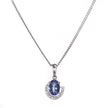 A white gold chain necklace with an oval blue gemstone pendant, surrounded by a crescent-shaped halo of small clear stones, shown on a plain white background.