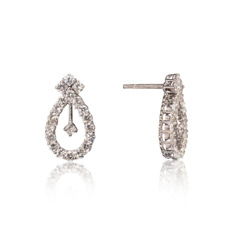 A pair of teardrop-shaped drop earrings paved with clear stones, shown from the front and side on a white background with a soft reflection.