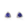 A pair of triangular stud earrings featuring a central blue tanzite gemstone surrounded by a halo of small clear stones in a white gold setting, shown on a white background with a soft reflection.