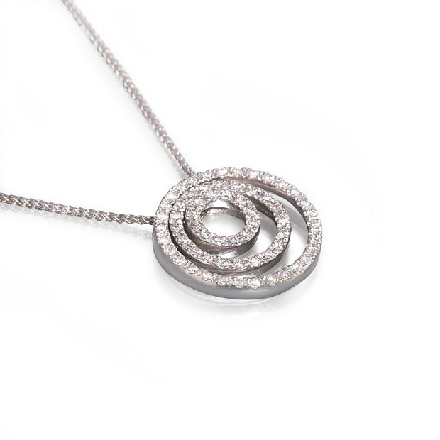 A white gold spiral pendant necklace paved with small clear stones, shown on a white background.
