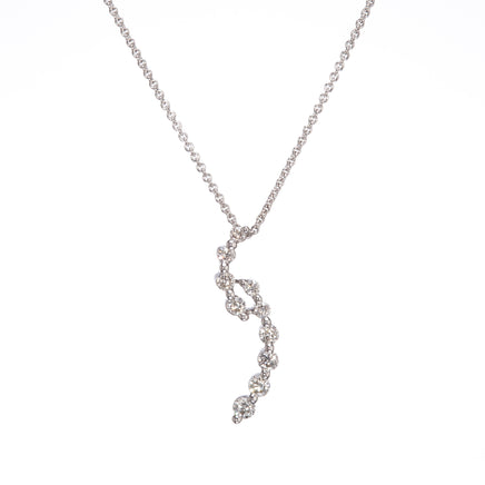A delicate white gold chain necklace featuring a wavy, spiral pendant set with clear gemstones, shown against a plain white background.