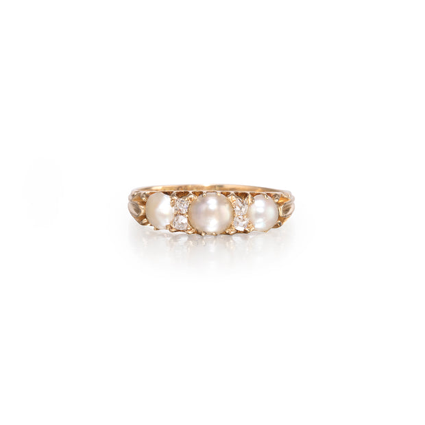 A vintage-style yellow gold ring featuring three large white pearls and small clear accent stones, set against a clean white background.