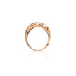 A gold ring featuring a cluster of white pearls at the top, shown against a plain white background with a soft reflection below.
