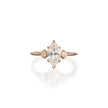 A yellow gold ring featuring a marquise-cut diamond center stone with two smaller round-cut diamonds on the sides, set against a clean white background with a soft reflection.