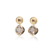 Gold earrings with clear gemstones on a white background