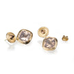 Gold earrings with clear gemstones on a white background