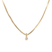A delicate yellow gold snake chain necklace with a small, round-cut clear gemstone pendant, shown against a solid white background.
