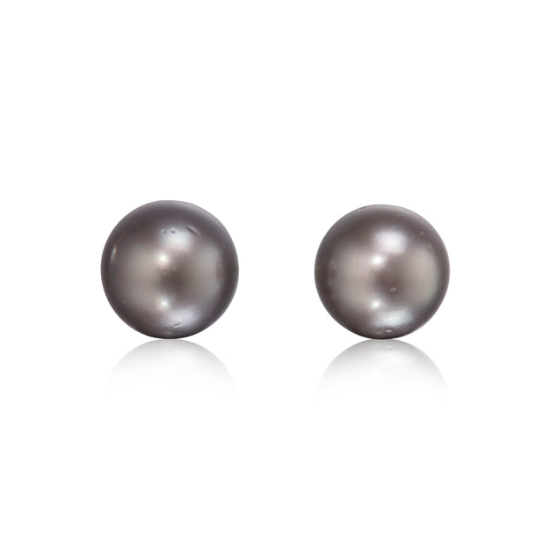 A pair of round dark gray freshwater pearls on a clean white background with soft reflections below.