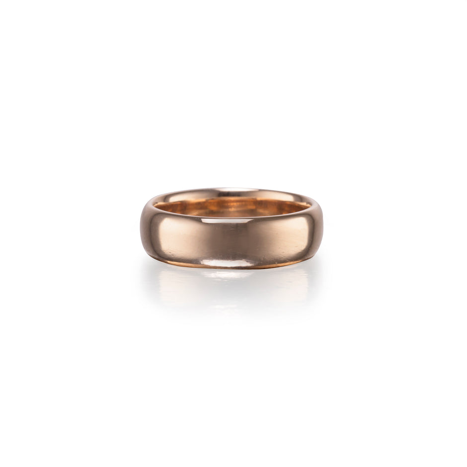 A polished rose gold band ring centered on a clean white background with a soft reflection underneath.
