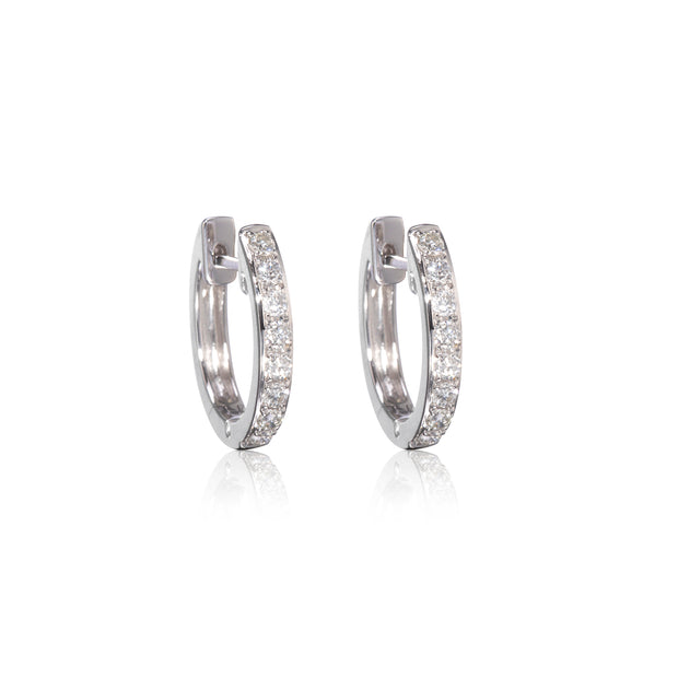 Pair of white gold diamond huggy earrings on a white background