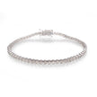 A white gold tennis bracelet with a continuous row of clear round-cut stones, displayed on a clean white reflective surface.