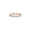 A rose gold eternity ring set with small round-cut clear gemstones, shown on a clean white background with a soft reflection.