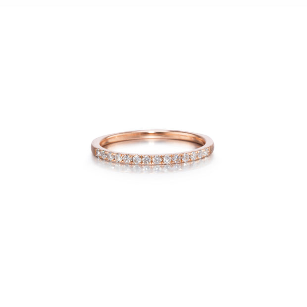 A rose gold eternity ring set with small round-cut clear gemstones, shown on a clean white background with a soft reflection.