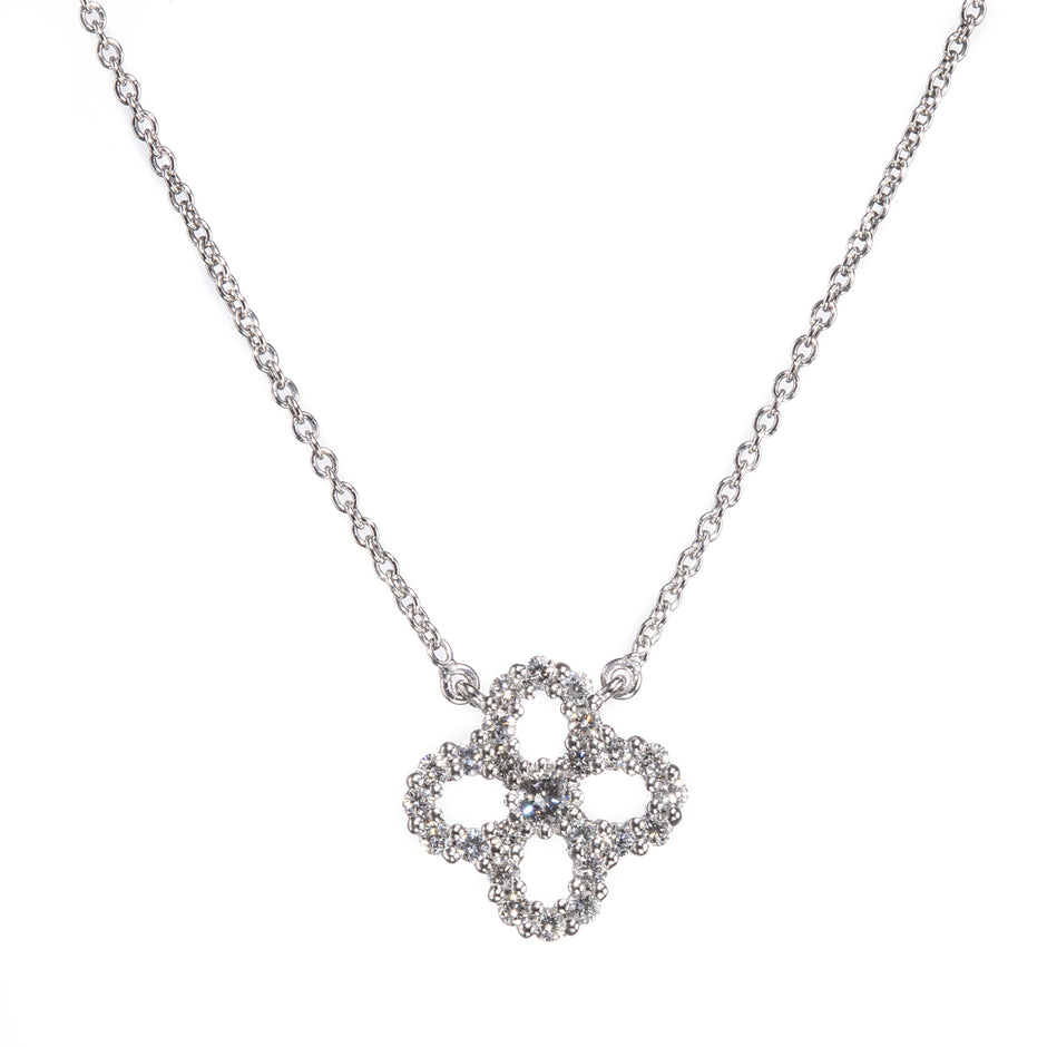 A white gold chain necklace with a four-petal clover pendant encrusted with small clear stones, shown against a plain white background.