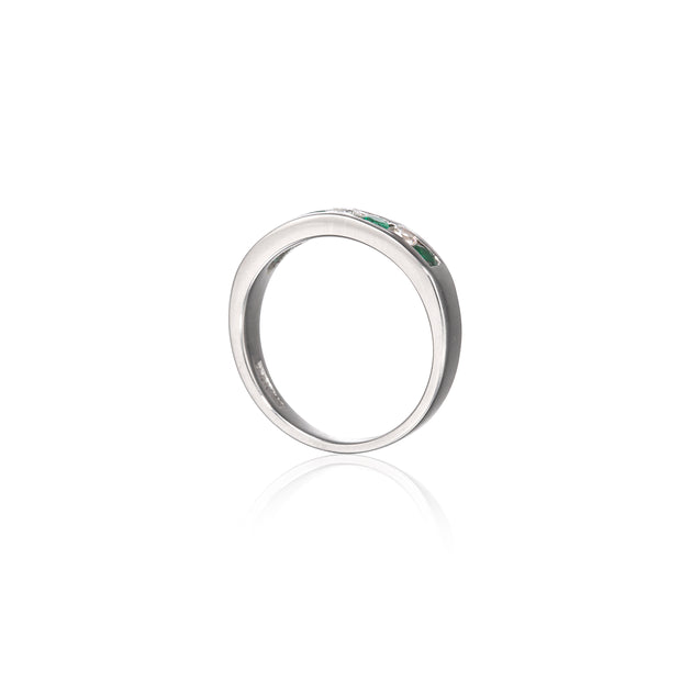 A white gold band ring featuring a row of small green gemstones on the front, displayed on a clean white background with a soft reflection below.