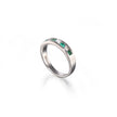 A white gold band ring featuring a row of green emerald-cut gemstones, photographed on a clean white background with a soft reflection.