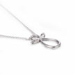 White gold bow-shaped pendant on a chain against a white background