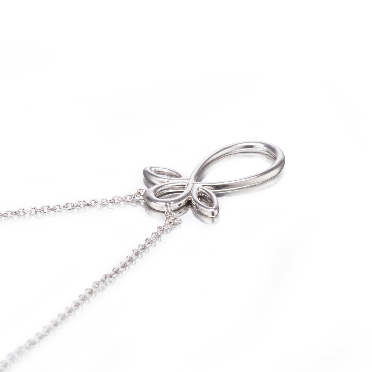 White gold bow-shaped pendant on a chain against a white background