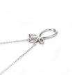 White gold bow-shaped pendant on a chain against a white background