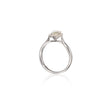 A white gold solitaire ring with a round-cut clear gemstone in a prong setting, shown on a clean white background with a soft reflection below.
