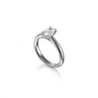 A platinum solitaire engagement ring with a round brilliant-cut diamond set in a four-prong setting, shown on a clean white background with a soft reflection.