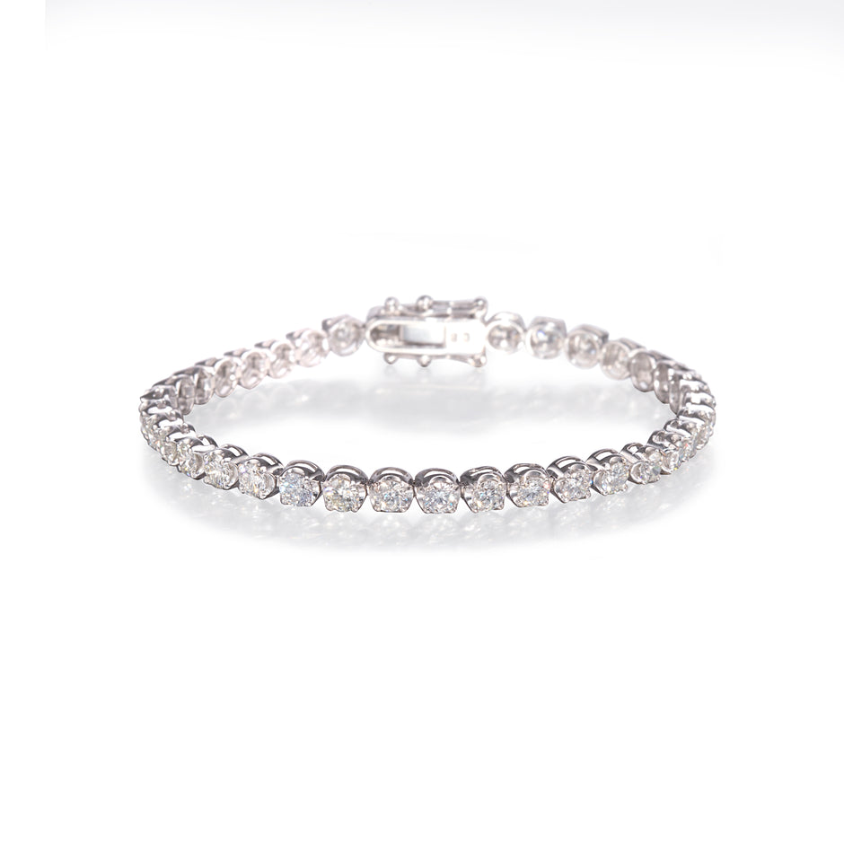 Platinum and rose gold diamond bracelet with clear stones on a white background